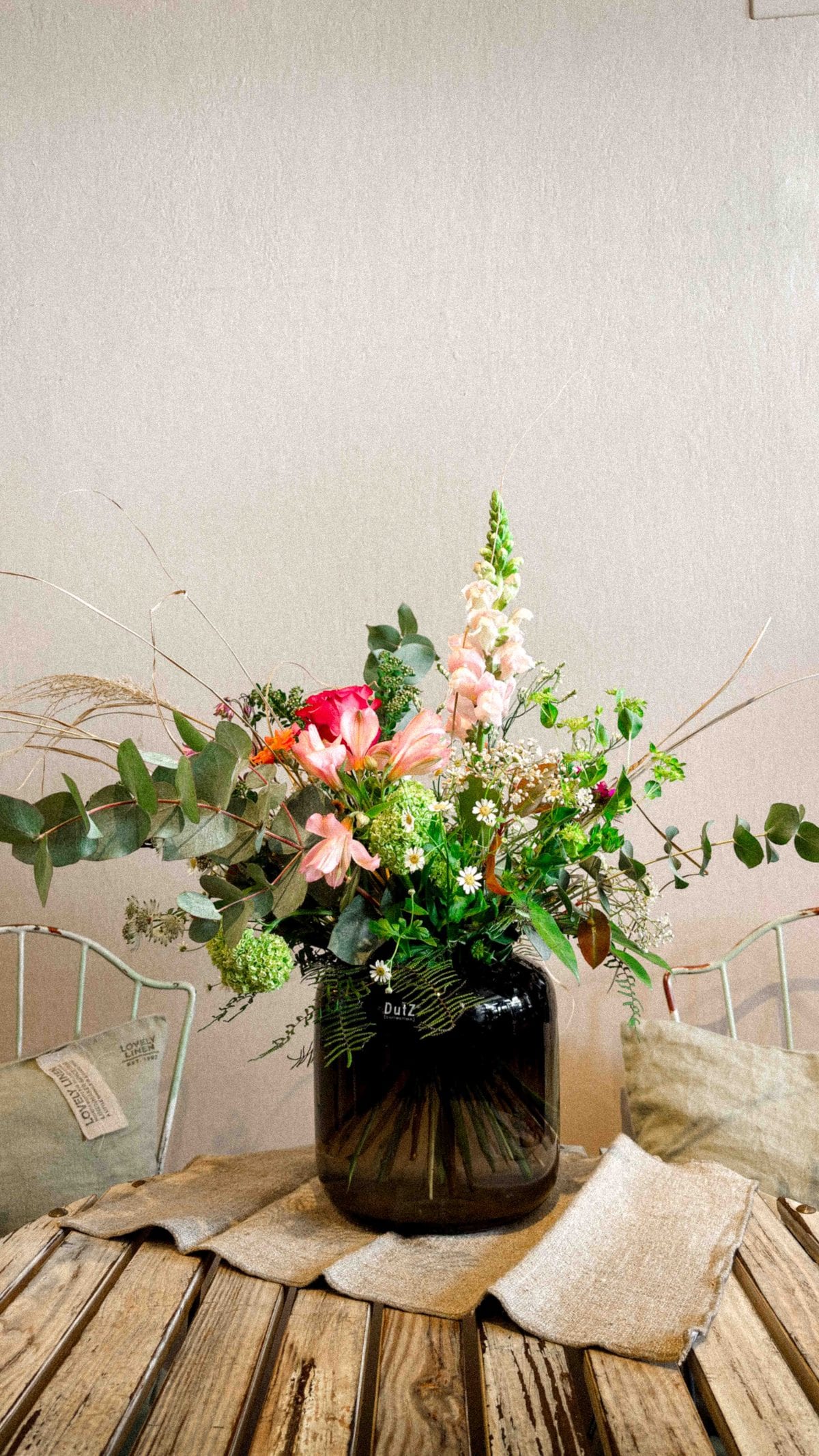 Blumenarrangement in einer dunklen Vase