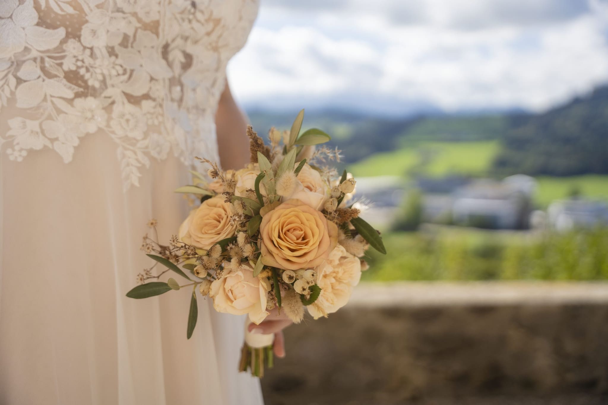 Brautstrauss in Pfirsich und Creme vor dem Blick ins Appenzellerland