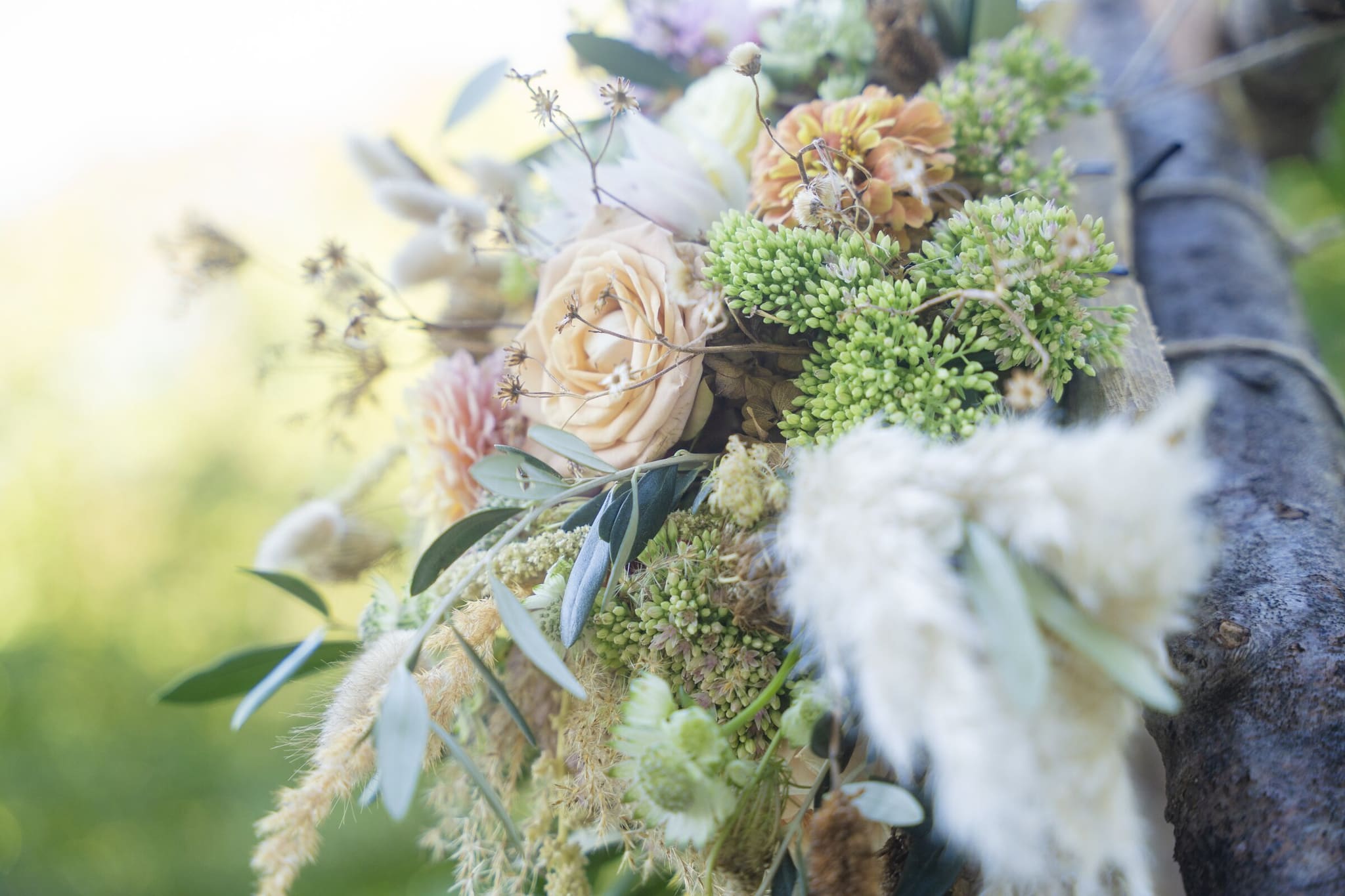 Nahaufnahme eines Hochzeitsgestecks mit Rosen, Trockengräsern und Pampas