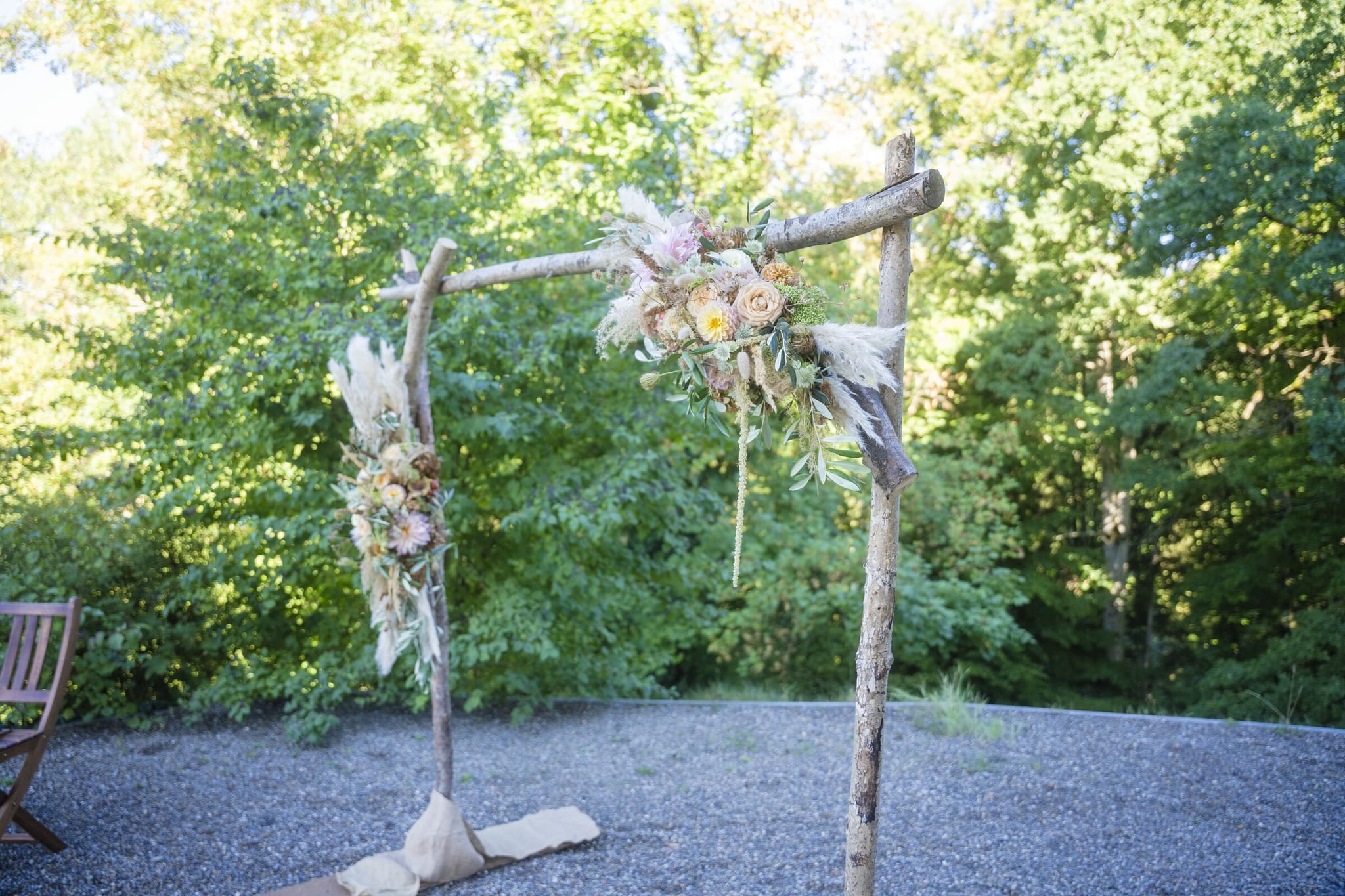 Traubogen aus Birkenholz mit Blumengesteck im Grünen