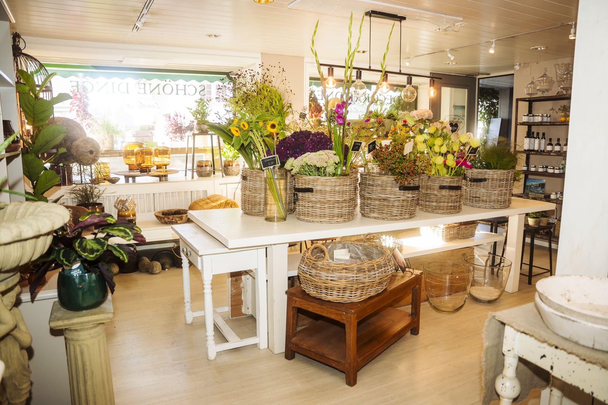 Der grosse Blumentisch bei Landleben voller frischer Blumen in Körben